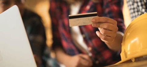 A closeup of a hand holding a credit card.
